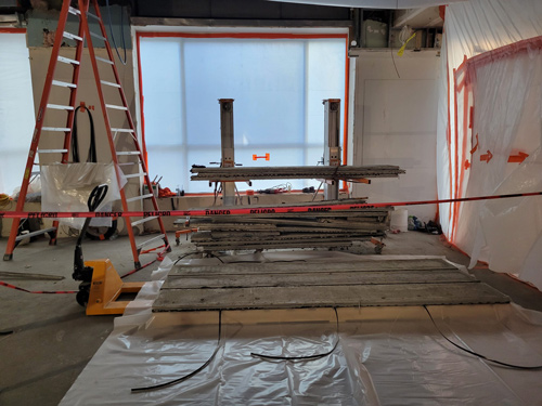 Peak Environmental site with a scaffold lift and planks in progress, surrounded by caution tape and protective plastic sheeting for containment, indicating work at Lumen Technologies.